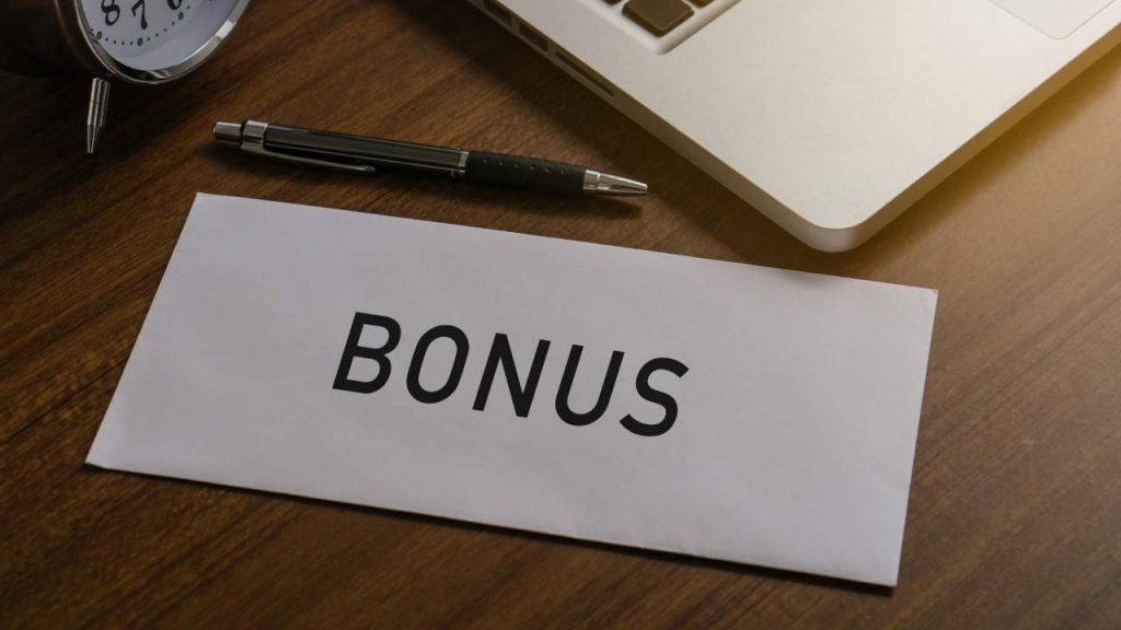 Bonus su una lettera bianca accanto ad una penna e al Pc