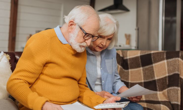 Coppia di anziani che legge i documenti pensionistici