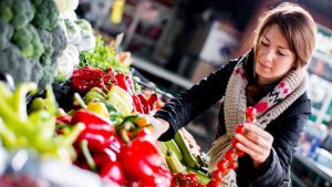 Donna che fa la spesa scegliendo attentamente la verdura da comprare
