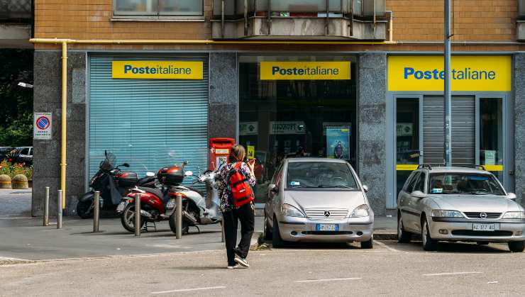 Donna che si accinge ad entrare in un ufficio postale