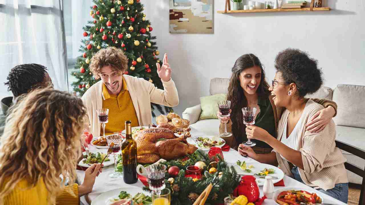 Famiglia felice e numerosa che festeggia il Natale mangiando insieme