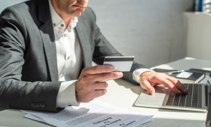 Uomo che si accinge a fare un bonifico con la sua carta di credito