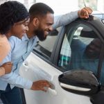 Giovane coppia in concessionaria che valuta l'automobile da acquistare