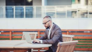 Giovane ragazzo che lavora in modalità smartworking all'aperto