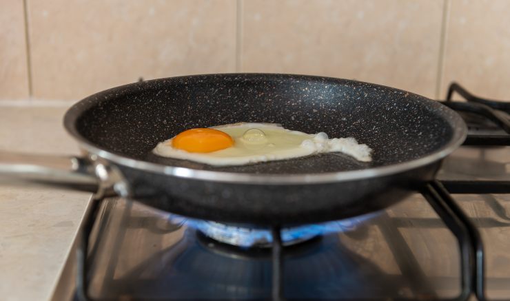 Un uovo cucinato in una padella riscaldata dal fuoco